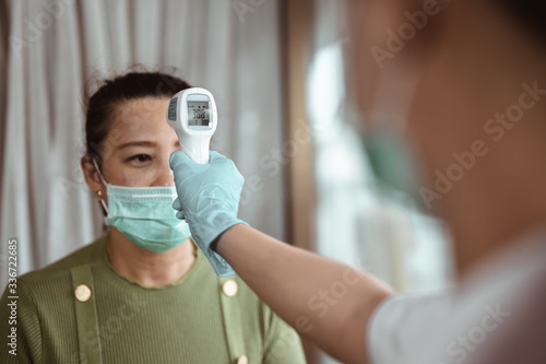 Doctor check patient body temperature using infrared forehead thermometer at hospital for Corona virus. Coronavirus, covid-19, Work from home, Social distancing, Quarantine, Prevent infection concept.