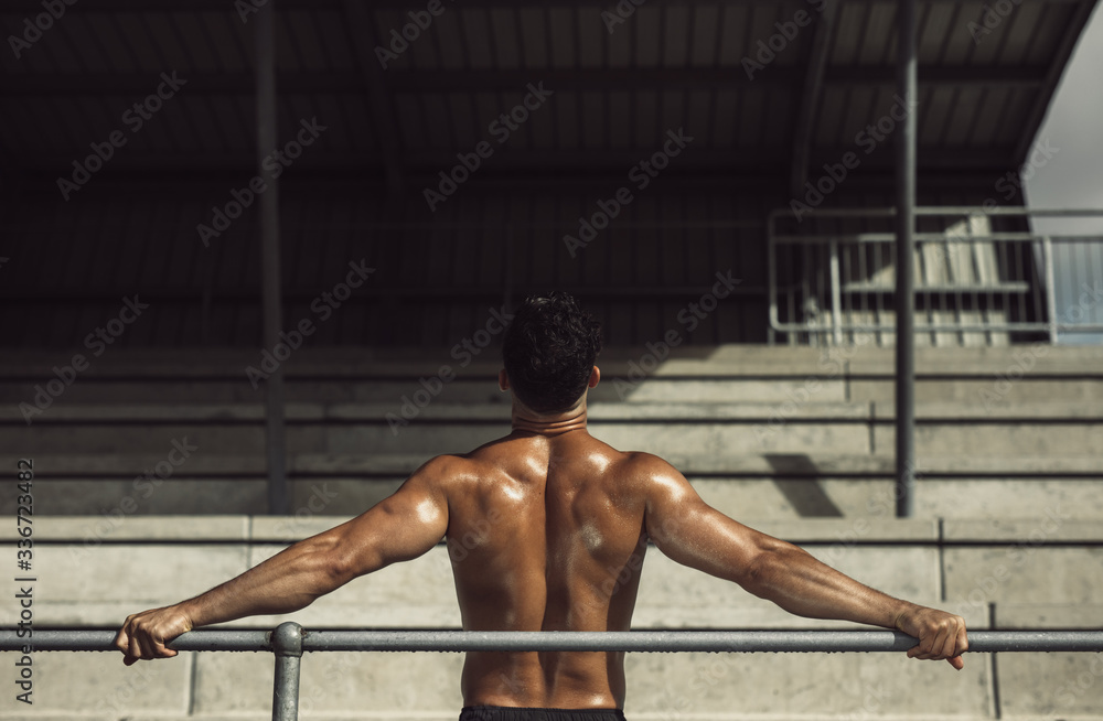 Muscular man resting in stadium stands