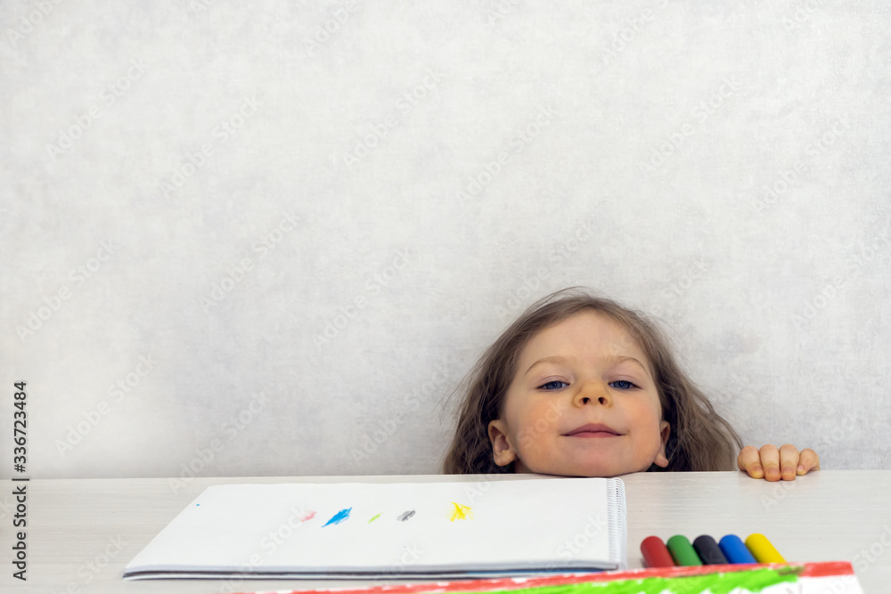 A three-year-old put her head on the drawing table