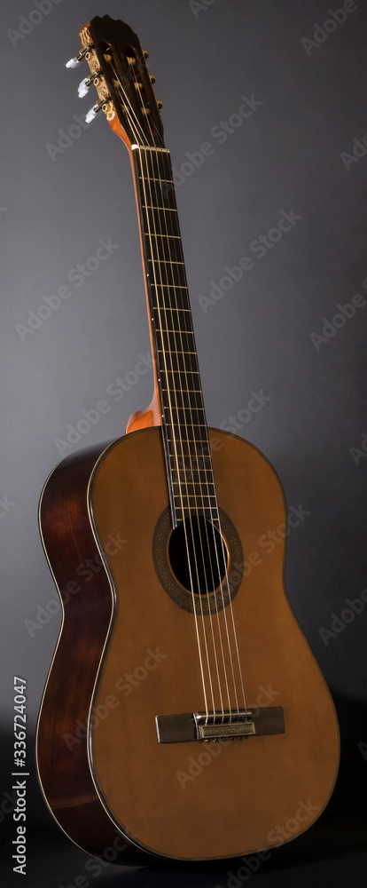 tilted six-string guitar against a dark background