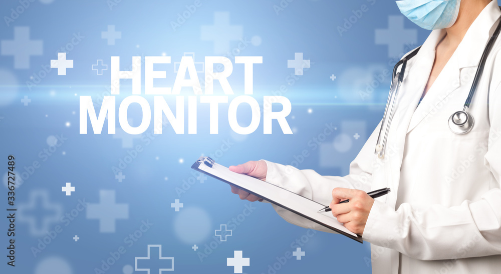 doctor writes notes on the clipboard with HEART MONITOR inscription, first aid concept doctor writes notes on the clipboard with HEART MONITOR inscription, first aid concept