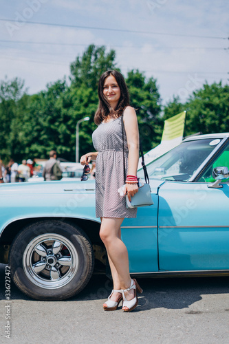 Beautiful girl on a summer sunny day near a muscle car © chdenisz