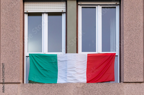 Italian flag displayed on the windows of buildings throughout Italy.