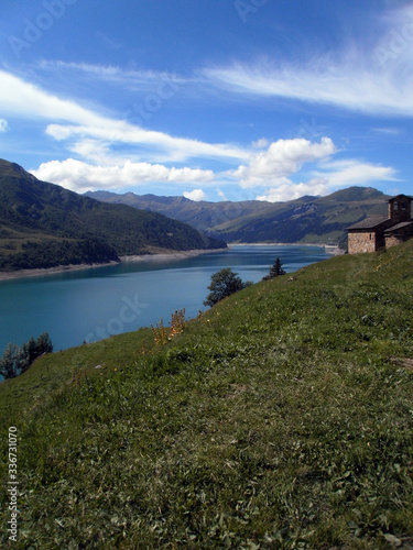 View of a small chapel and the lake Roselend, which is mainly a reservoir in the French alpine mountains.