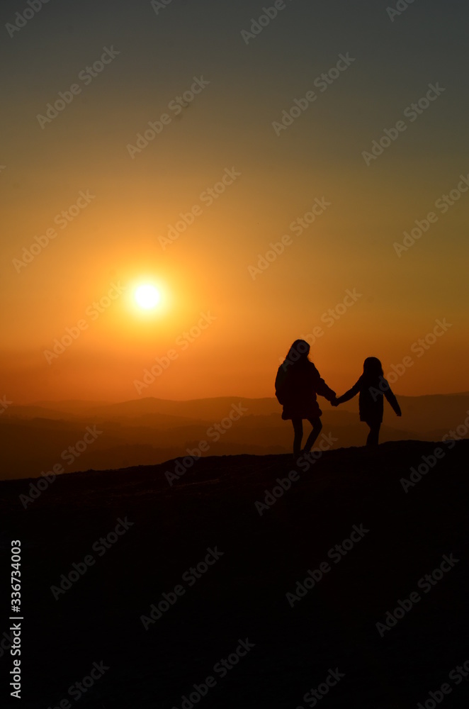 Mother and daughter watching the sunset.