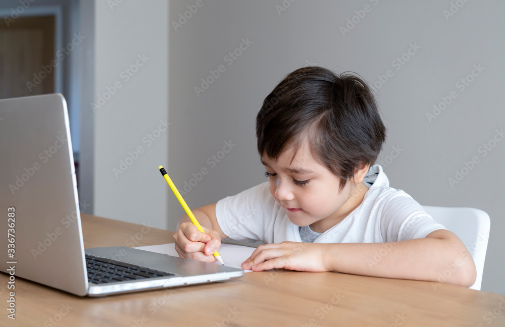 Home school Kid self isolation using laptop for his homework,Child doing using computer notebook searching information on internet during covid lock down, Social Distancing,E-learning online education Home school Kid self isolation using laptop for his homework,Child doing using computer notebook searching information on internet during covid lock down, Social Distancing,E-learning online education