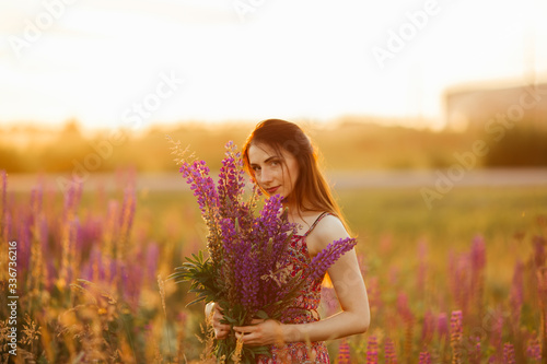 girl in a colored dress. Holds flowers in her hands