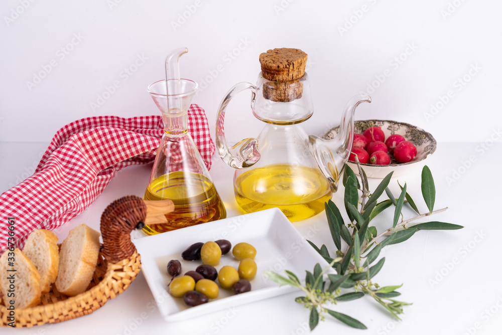 Table with oil cans, olives, bread and radishes