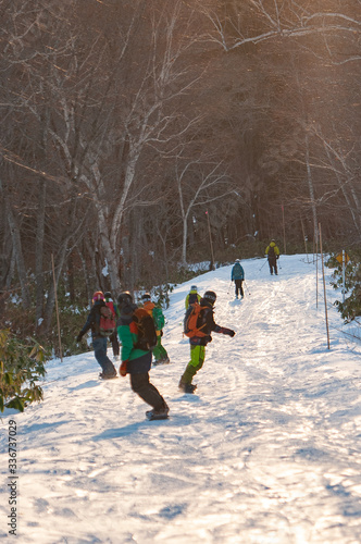 A sunny morning with a group of snowboarders leaving some fresh lines on a slope at the beginning of the season in Niseko, Japan.