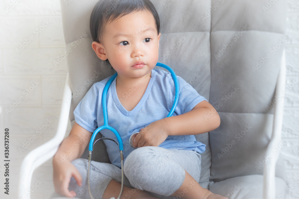 Little boy playing a doctor, children play doctor and hospital using stethoscope, having fun at home or preschool,Tool doctor,Smiling little boy sitting on chair isolated. Little boy playing a doctor, children play doctor and hospital using stethoscope, having fun at home or preschool,Tool doctor,Smiling little boy sitting on chair isolated.