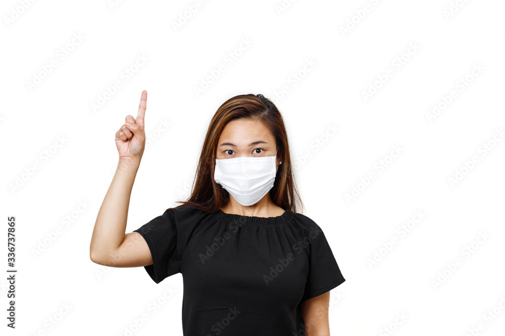 Plain white background. Asian lady with one hand finger pointing upward for text space. asian lady in black shirt. Lady looking straight wearing face mask to avoid spreading of coronavirus. Plain white background. Asian lady with one hand finger pointing upward for text space. asian lady in black shirt. Lady looking straight wearing face mask to avoid spreading of coronavirus.