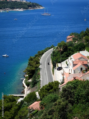Winding road at the azure coast of Croatia  man on a motorbike.