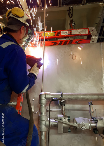 Welder working in a stainless steel hydraulic pipeline