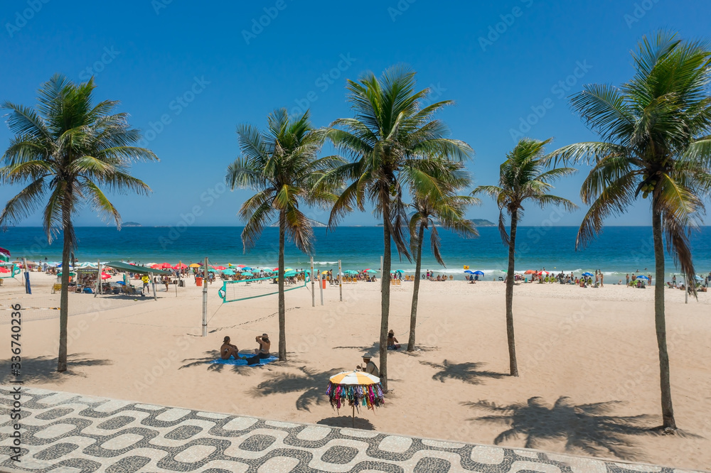 Few palm trees on Ipanema beach during sunny day in Rio de Janeiro