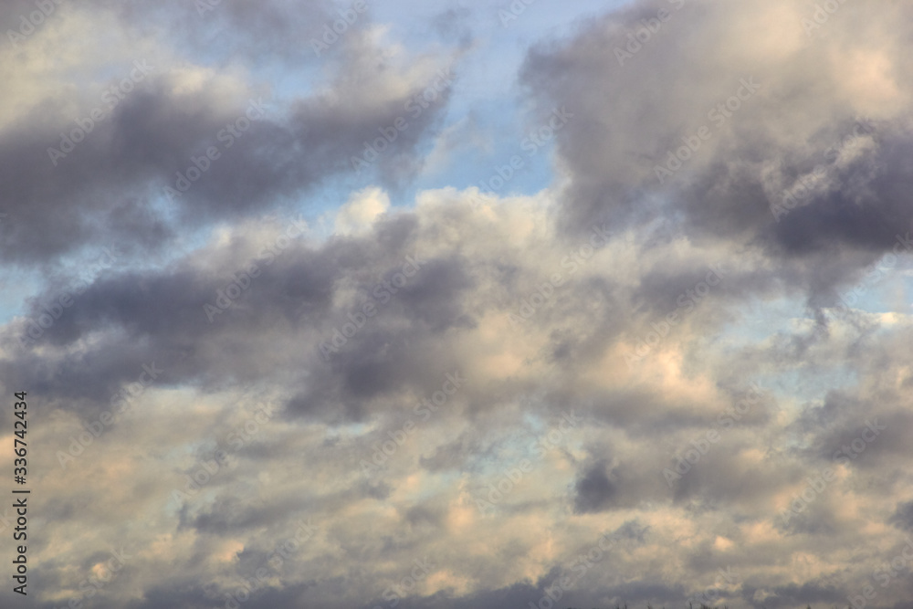 low-floating Cumulus clouds at dawn against a blue sky