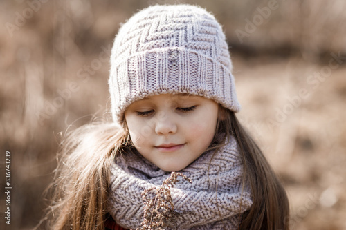 portrait of a little girl in a hat in the spring forest