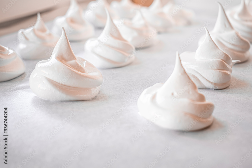 Lots of homemade meringue on a baking sheet Lots of homemade meringue on a baking sheet