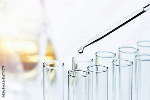 Glass pipette with a drop of liquid and glass tubes
