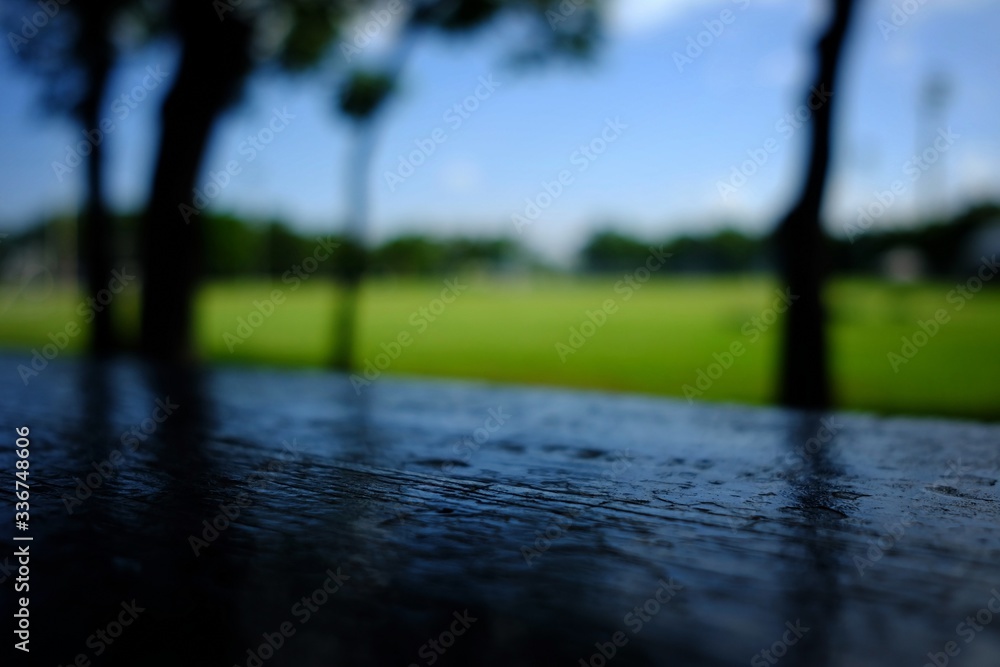 Fototapeta premium Black Wooden Table with Blurred Soccer Field Background.