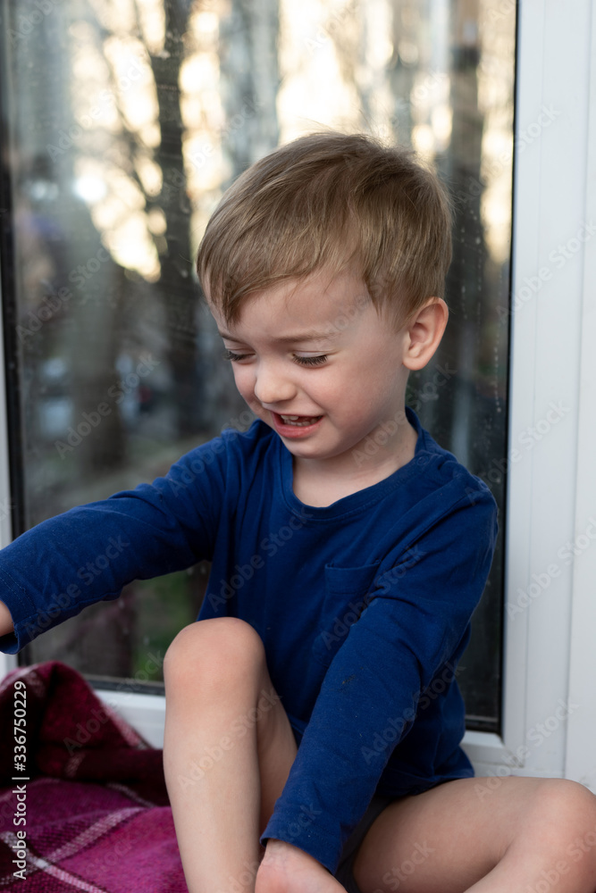 portrait of a crying little boy against the window portrait of a crying little boy against the window