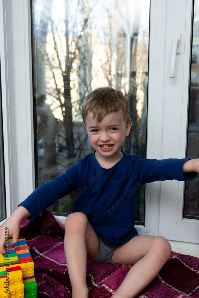 portrait of a crying little boy on the background of a window. portrait of a crying little boy on the background of a window.