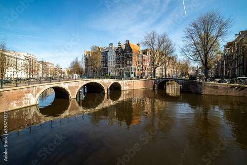 Fototapeta Naklejka Na Ścianę i Meble -  Typical facade fronts of ancient houses in Amsterdam at the keizersgracht, the probably most famous view -reflecting in the water shot with a wide angle lens