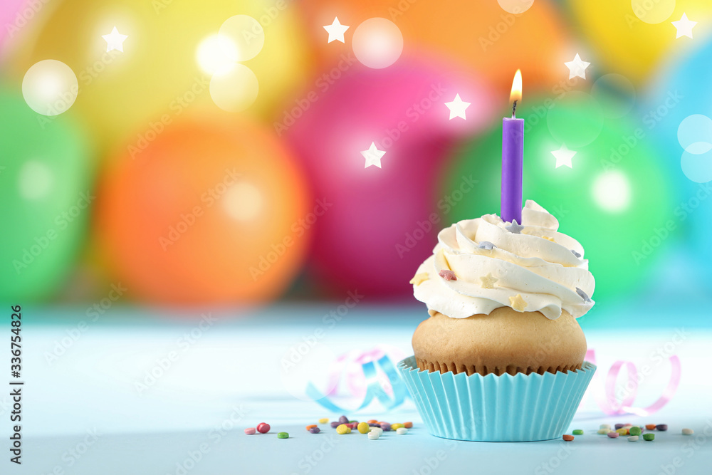 Birthday cupcake with burning candle on table against blurred background, space for text. Bokeh effect
