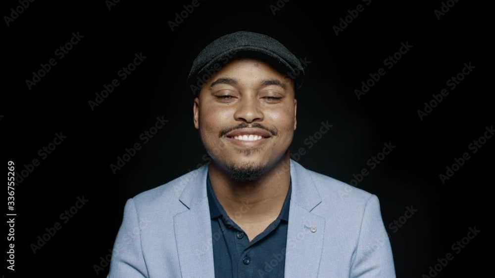 Smiling man in suit and cap looking at camera. Close up of smiling african american businessman isolated on black background.
Smiling man in suit and cap looking at camera. Close up of smiling african american businessman isolated on black background.