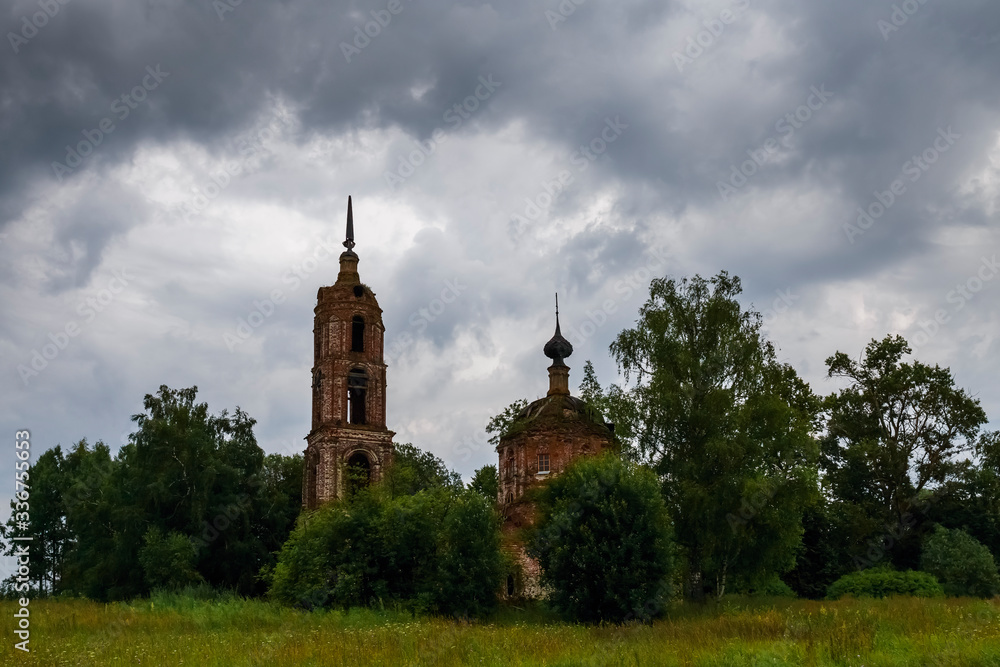 A cloudy landscape with an abandoned Church standing among trees. Ivanovo region, Russia. A cloudy landscape with an abandoned Church standing among trees. Ivanovo region, Russia.