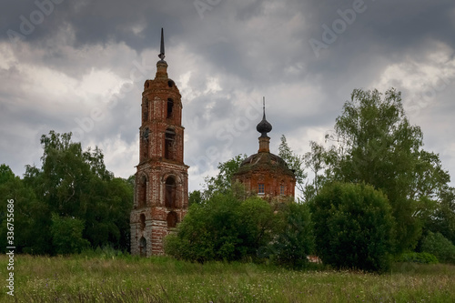 A cloudy landscape with an abandoned Church standing among trees. Ivanovo region, Russia.