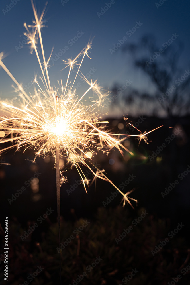 Burning sparkler as the highlight of a wonderful celebration; blurred background