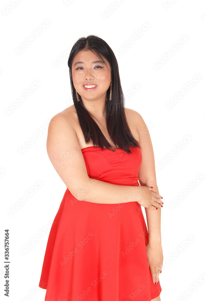 Happy Asian woman in a red dress standing in the studio Happy Asian woman in a red dress standing in the studio