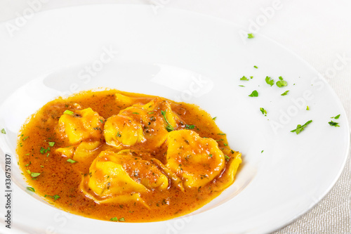 Plate of tortellini with fish sauce. Tortellini, homemade cappelletti. Menu photography.