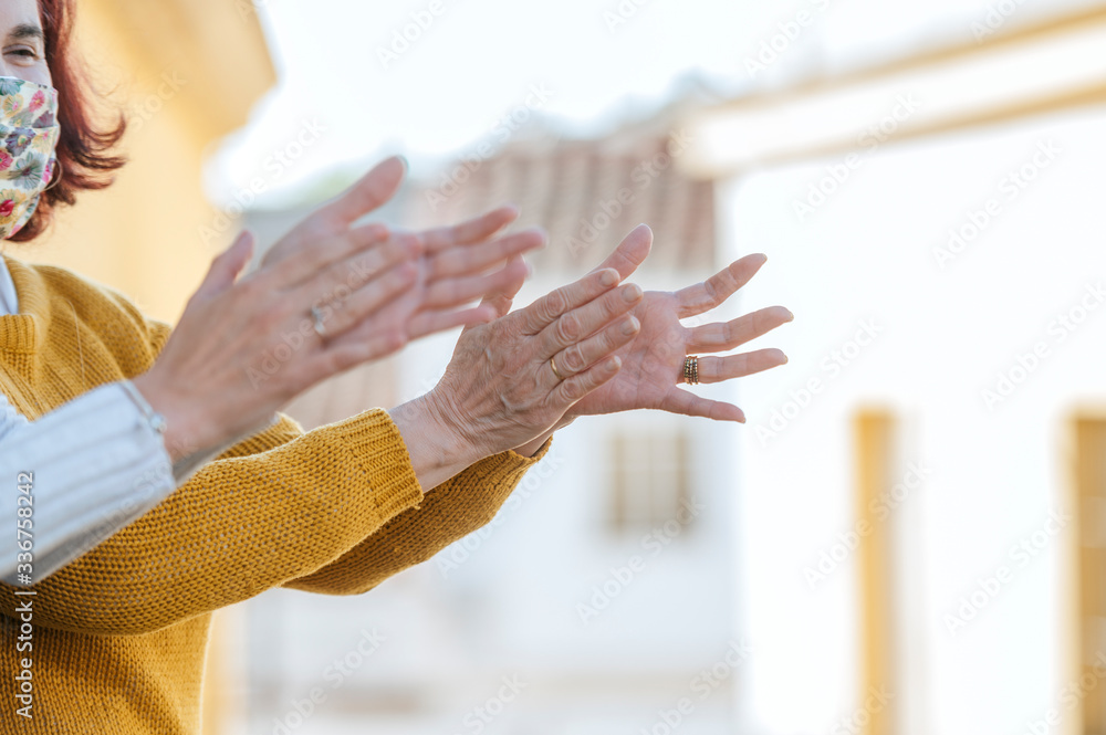 Obraz premium Two women clapping on the balcony