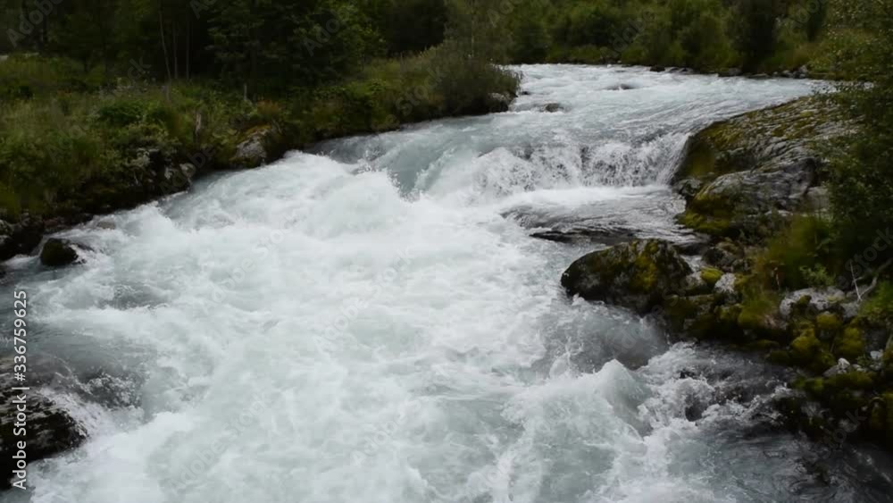 River which is located near path to the Briksdalsbreen (Briksdal) glacier. The melting of this glacier forms waterfall and river with clear water. Jostedalsbreen National Park. Norway. River which is located near path to the Briksdalsbreen (Briksdal) glacier. The melting of this glacier forms waterfall and river with clear water. Jostedalsbreen National Park. Norway.