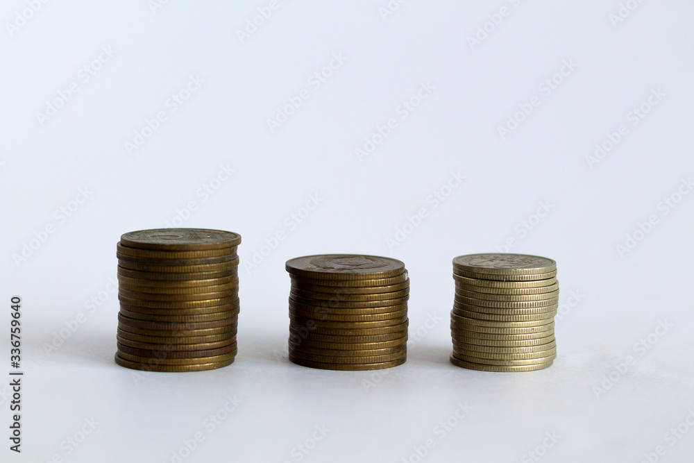 three stacks of coins on the white table. copy space. finance. payment of bills three stacks of coins on the white table. copy space. finance. payment of bills