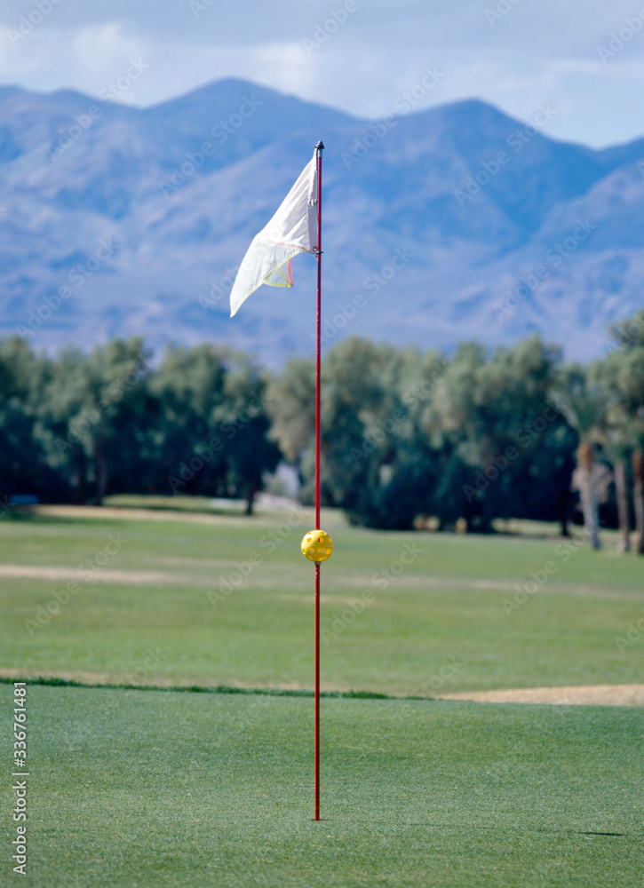 Obraz premium A white golf flag blowing in the wind