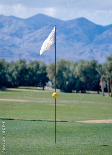 A white golf flag blowing in the wind