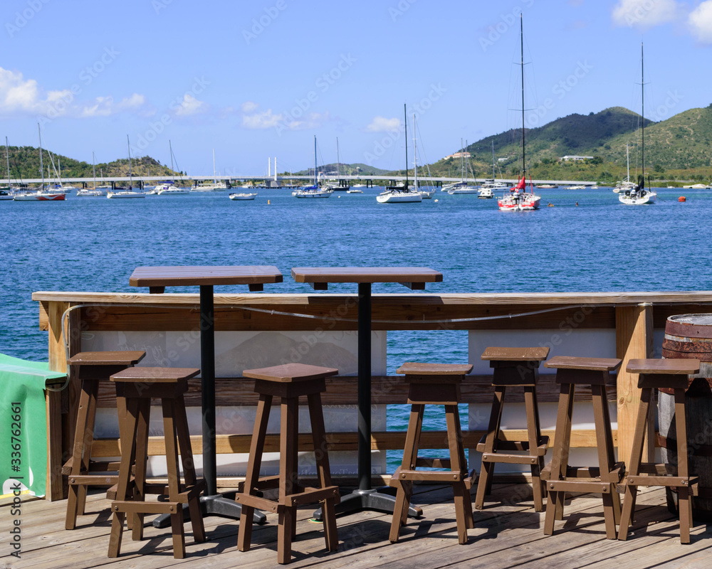 Impact on summer tourism & travel: normally busy, tables with a view at a popular Caribbean Bar & Restaurant (SMYC) remain empty while closed for the Coronavirus / Covid-19 Pandemic