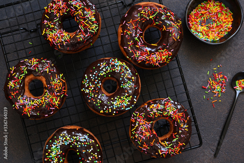 American donut with chocolate and candy on a concrete background.