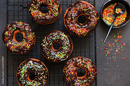 American donut with chocolate and candy on a concrete background.