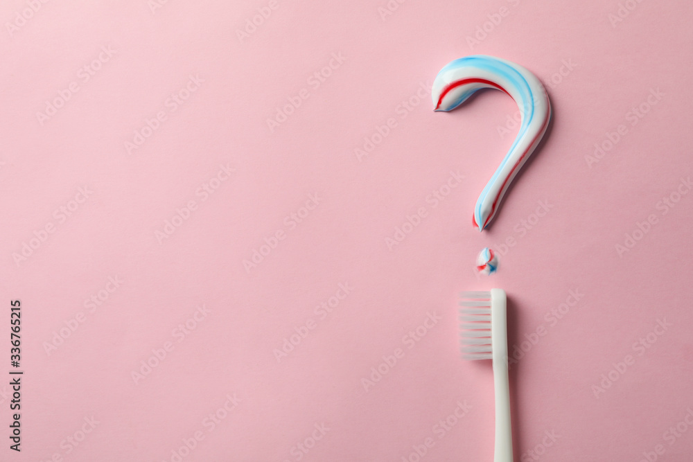 Question mark made of toothpaste and toothbrush on pink background Question mark made of toothpaste and toothbrush on pink background