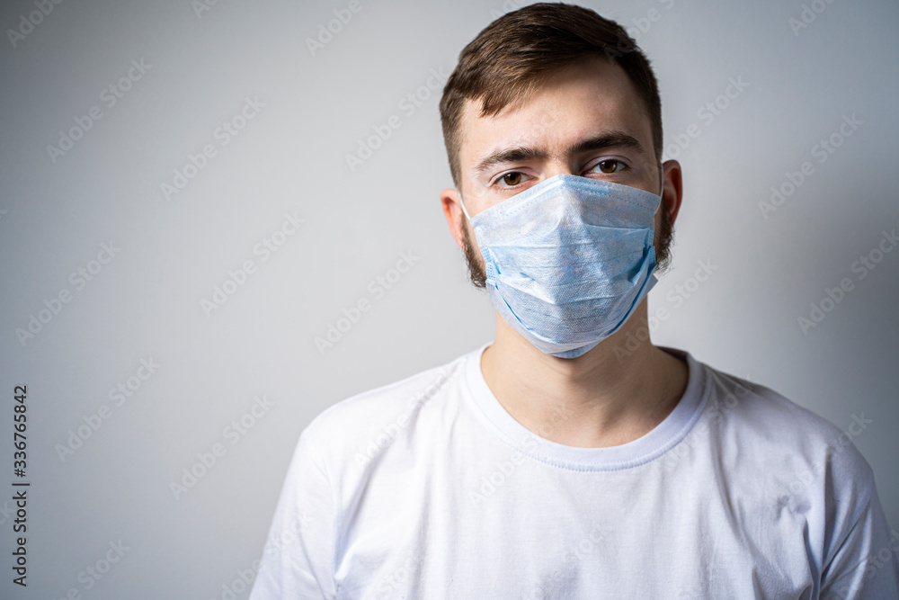 A bearded man in a medical mask looks at the camera. Self isolation A bearded man in a medical mask looks at the camera. Self isolation