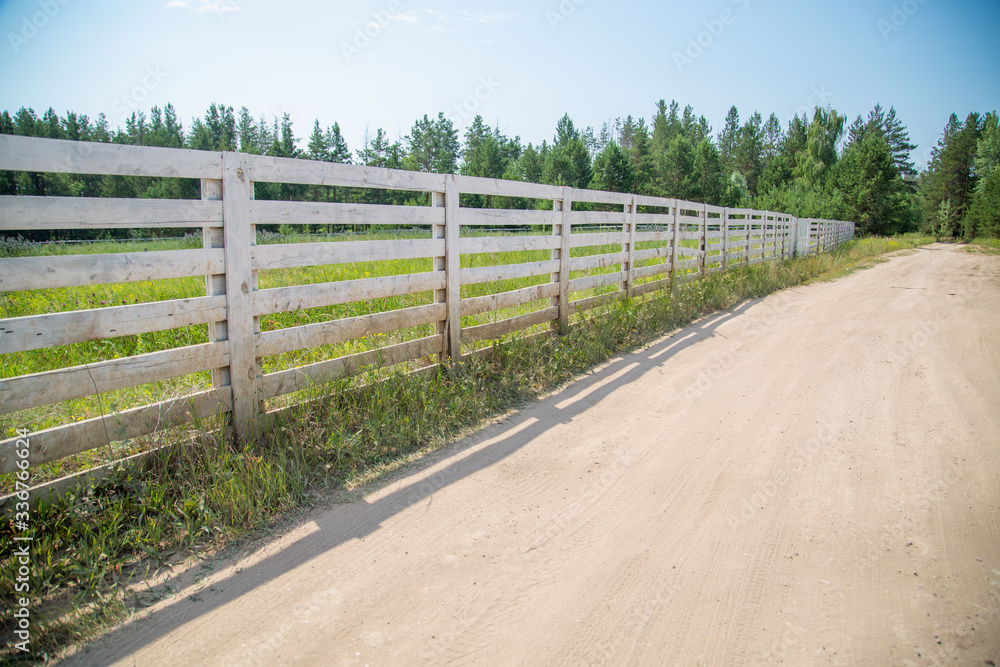white wooden fence of a farm on a sunny day