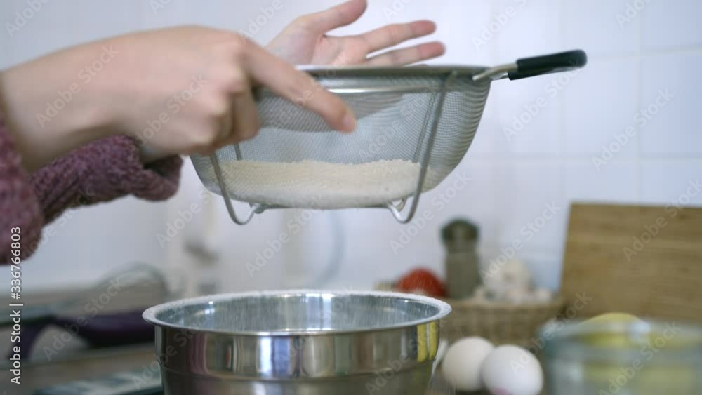 girl sifting flour in bowl girl sifting flour in bowl