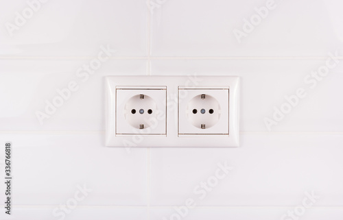 Double socket on white tile background. European electrical outlet