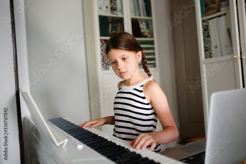 Remote music lesson, child playing digital piano photo