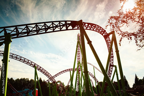 Roller coaster silhouette at sunset in an amusement park. Summer panorama. Background