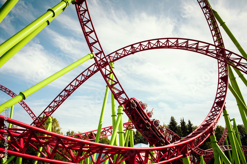 Rollercoaster large loops in an amusement park. Summer panorama. Background