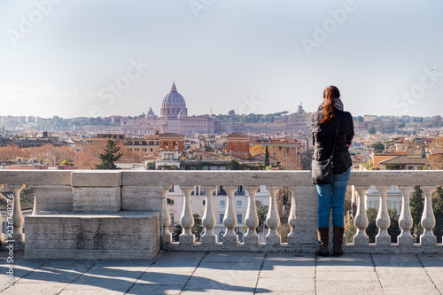 A girl admires the view of the city of Roma from above, from the hill of Terrazza del Pincio. Italy 
